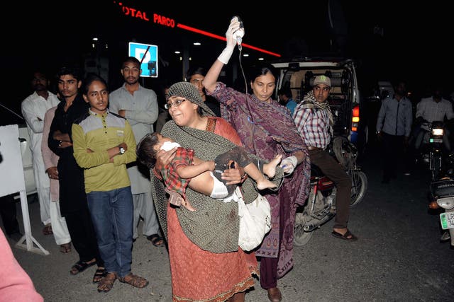 Relatives carry an injured child to a hospital in Lahore on March 27, 2016.
