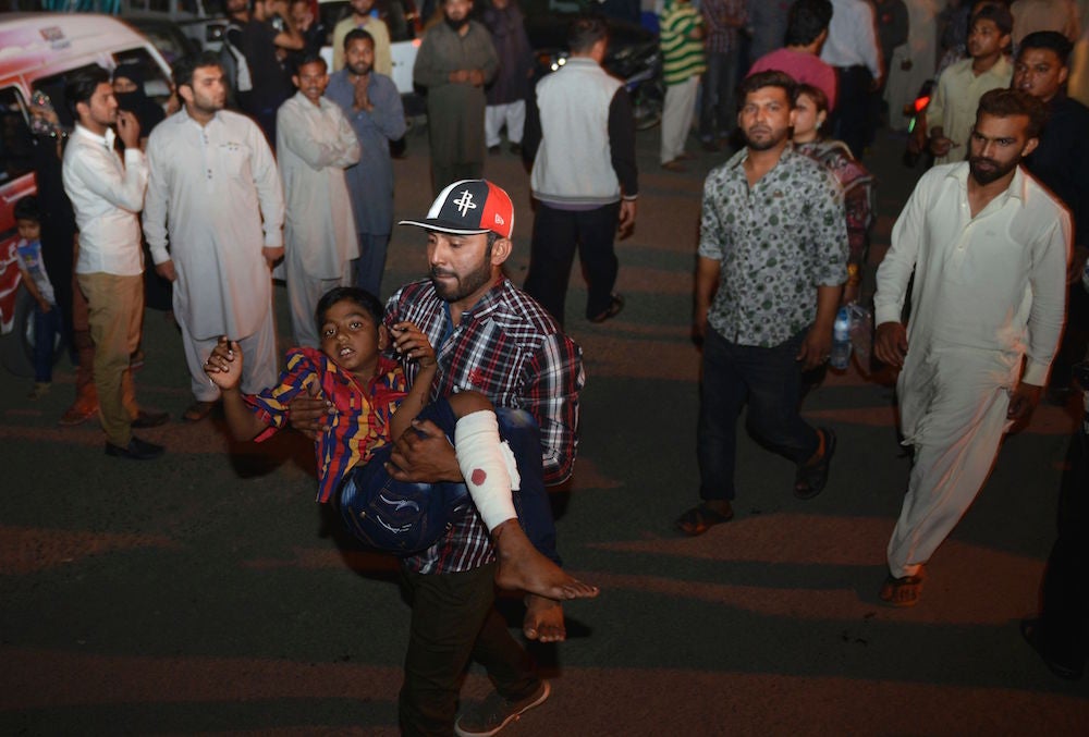 A man carries an injured child to a hospital in Lahore.
