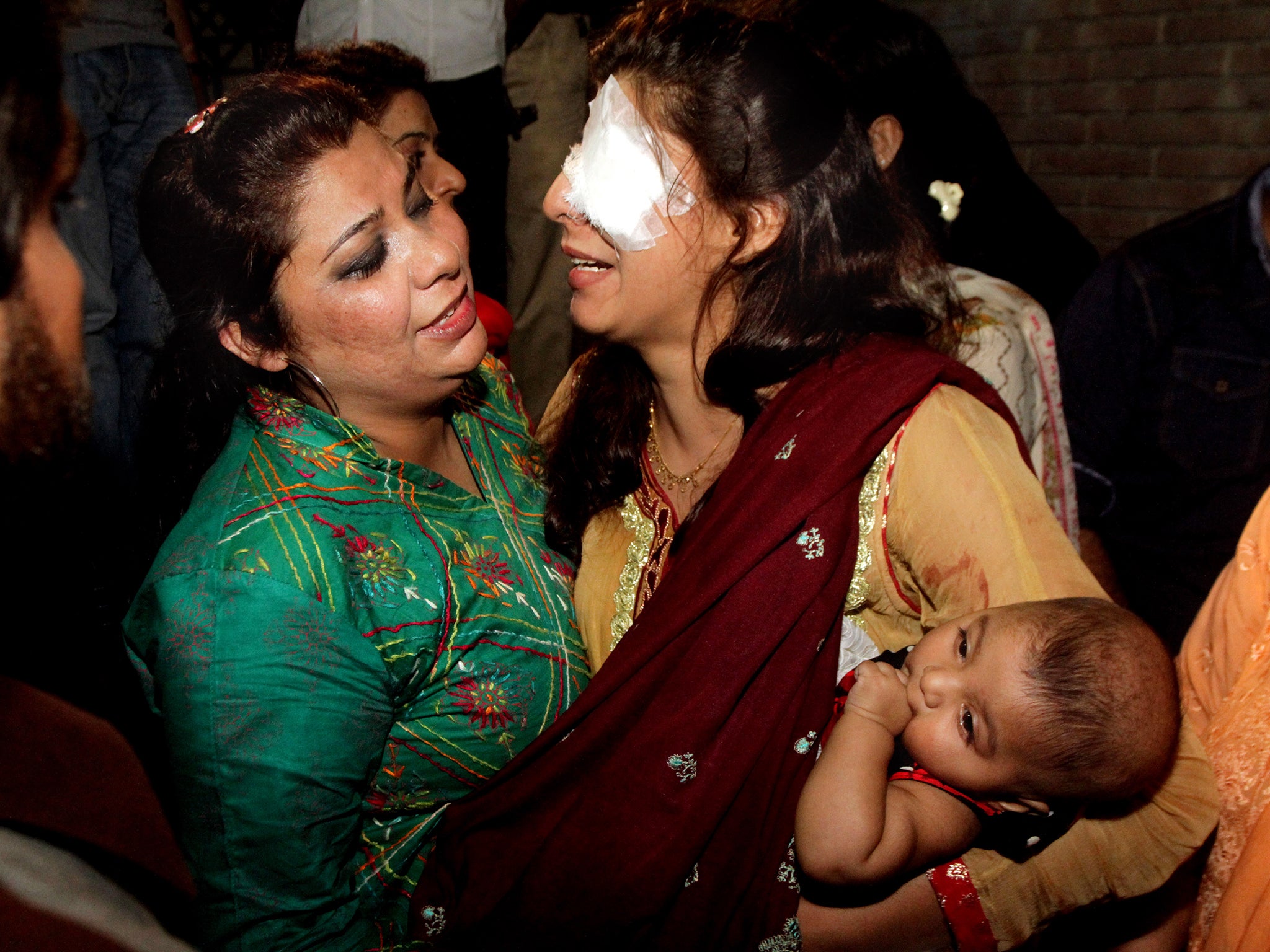 A woman injured in the bomb blast is comforted by a family member at a local hospital in Lahore, Pakistan
