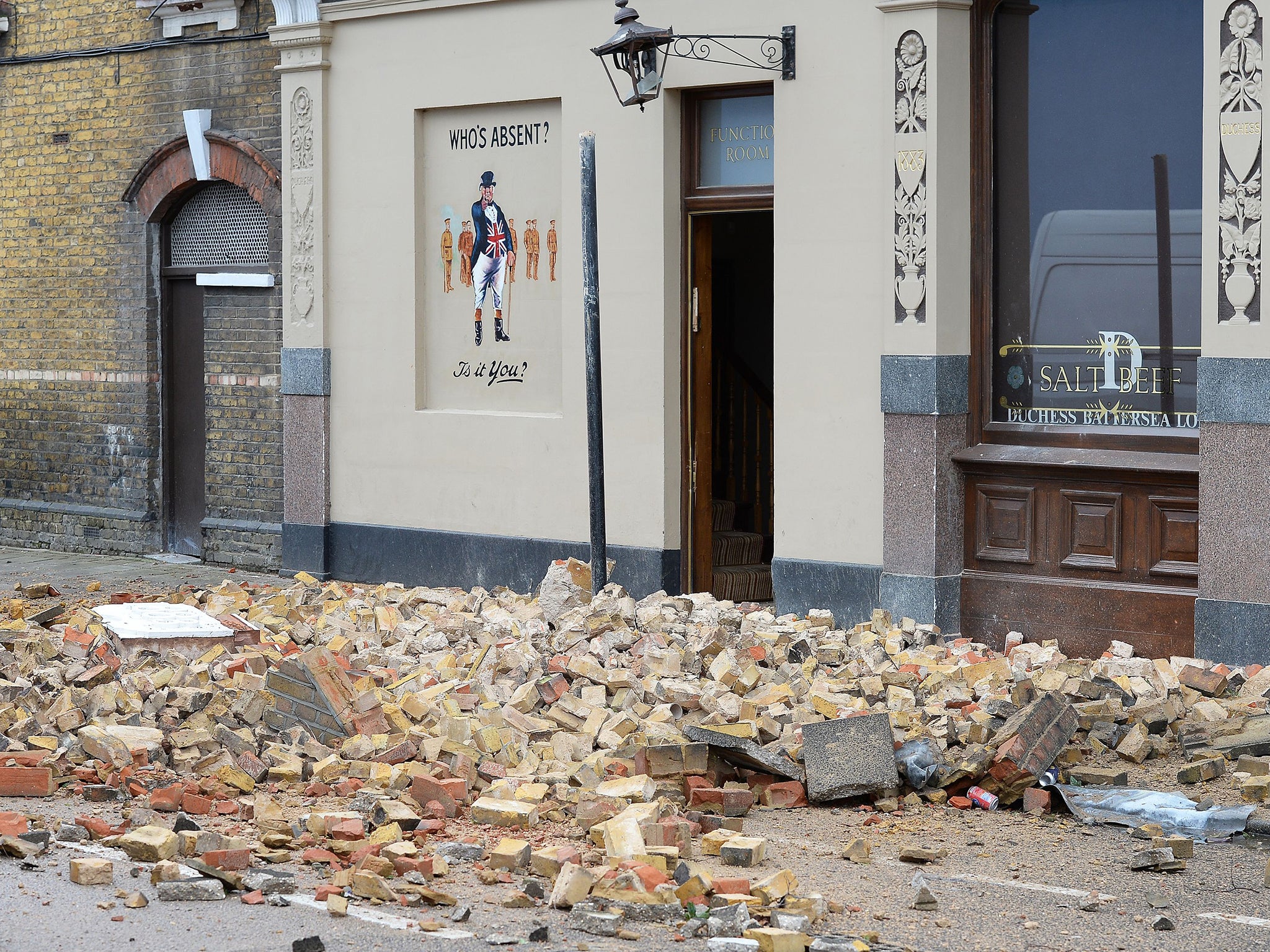 Rubble strewn across the road outside The Duchess public house in Battersea, south west London, after Storm Katie's high winds brought down part of the building's roof support.