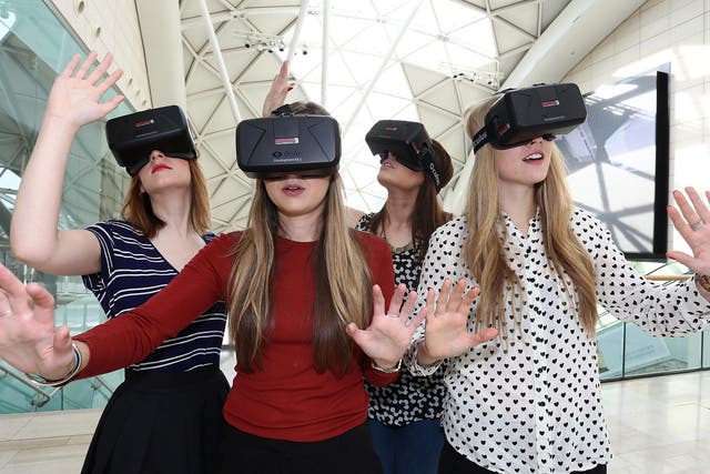 Women use the Oculus Rift DK2 at the Westfield Shopping Centre in London