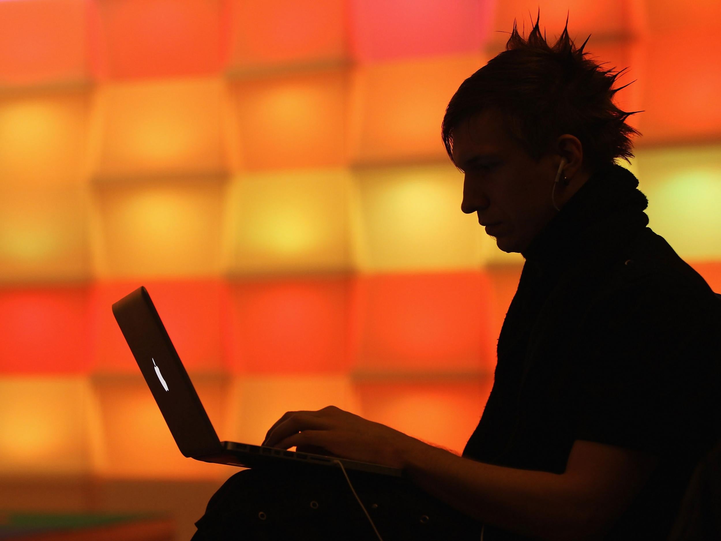 A participant sits with a laptop computer as he attends the annual Chaos Communication Congress of the Chaos Computer Club at the Berlin Congress Center in Berlin, Germany. The Chaos Computer Club is Europe's biggest network of computer hackers and its annual congress draws up to 3,000 participants.