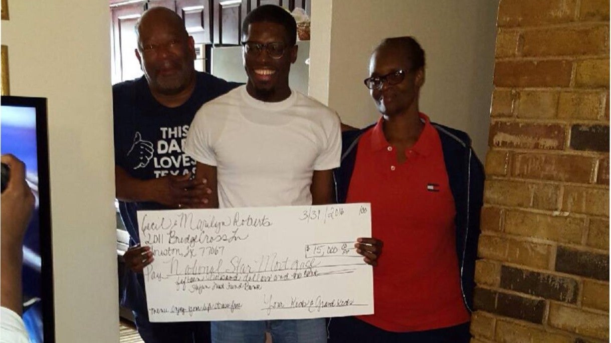Darts, pictured centre, presents his grandparents with the life-changing cheque
