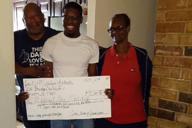Darts, pictured centre, presents his grandparents with the life-changing cheque