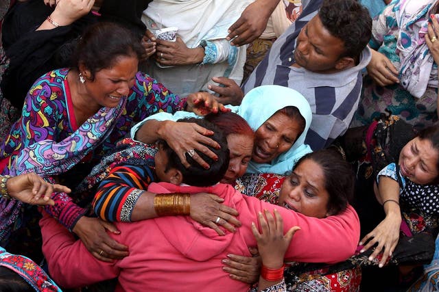 People cry during the funeral of their loved ones a day after a suicide bomb attack at a park, in Lahore, Pakistan
