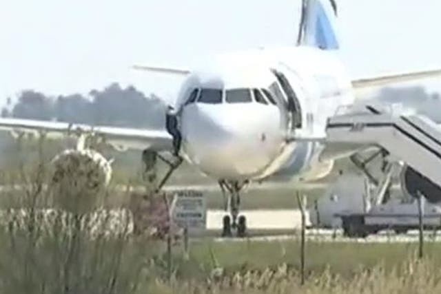 An unidentified man was filmed escaping out of the plane's cockpit window as the hostage situation continued