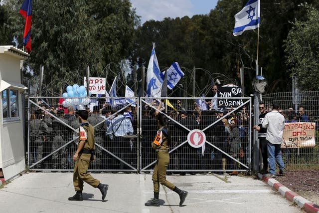 Israeli right-wing protesters demonstrate outside a military court during a hearing of an Israeli soldier who the military said has been arrested on suspicion of murder, near the southern Israeli city of Kiryat Malachi, 29 March, 2016