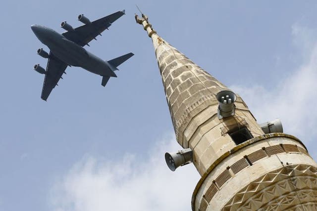 A US Air Force Boeing C-17A Globemaster III large transport aircraft flies over a minaret after taking off from Incirlik air base in Adana, Turkey, on 12 August, 2015