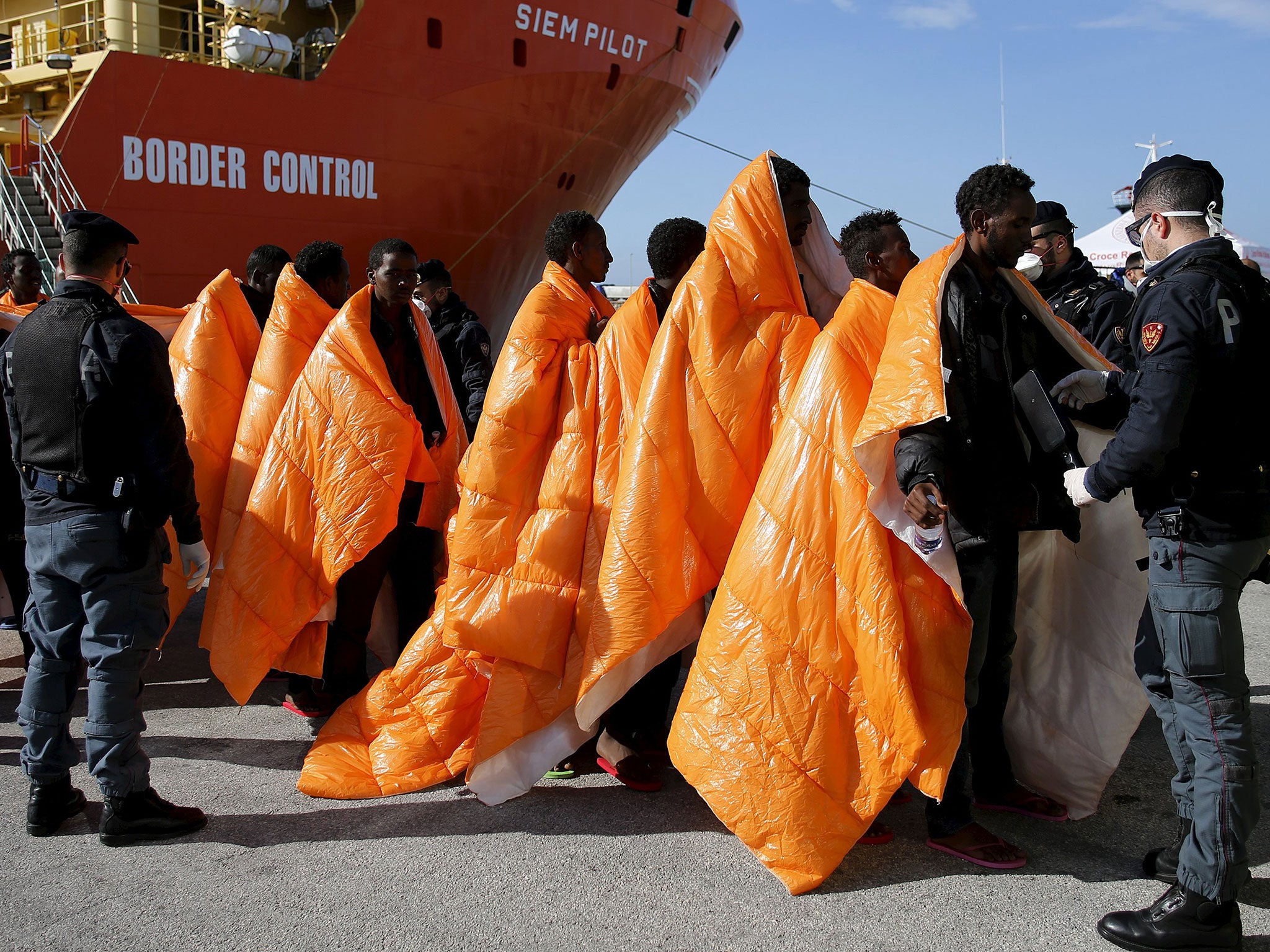 Migrants are inspected by policemen as they disembark from the Norwegian vessel Siem Pilot at Pozzallo's harbour, Italy, March 29, 2016.