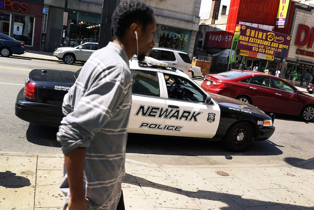 A man walks by a police car in downtown Newark, New Jersey.