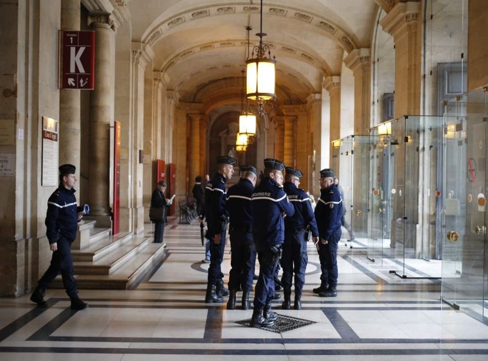 French gendarmes patrol in the Paris hall of Justice while Reda Kriket is being questioned by a magistrate who then filed preliminary terror charges