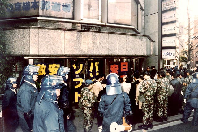 Riot policemen surround the Tokyo headquarters of the controversial Aum sect, on March 22, 1995.