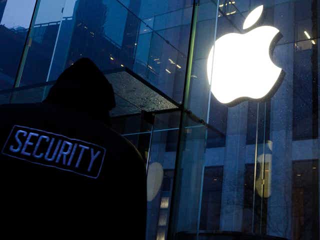 A security guard patrolling in front of an Apple Store