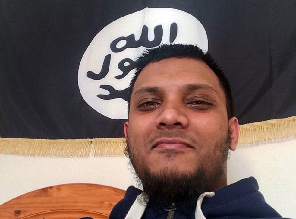 Junead Khan posing in front of an Isis-style flag at his home in Luton in a picture found on his phone.