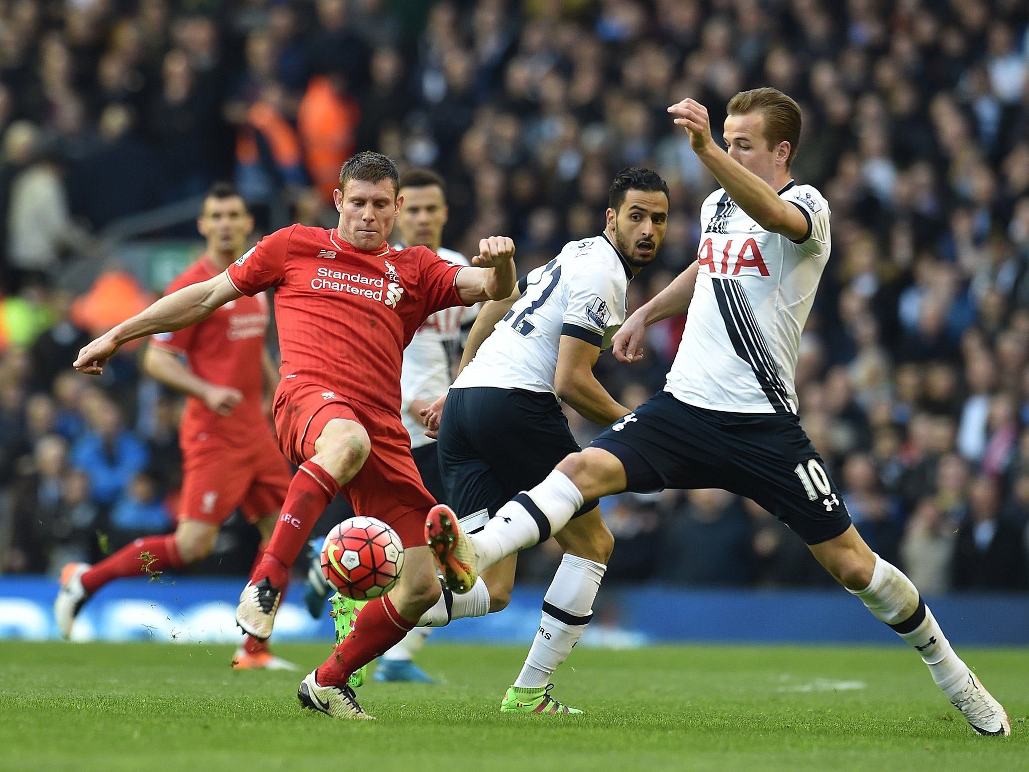 James Milner competes with Harry Kane for the ball