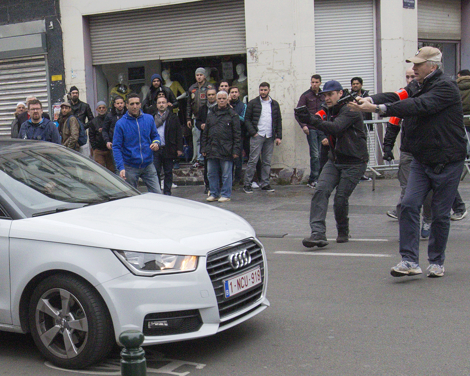 Belgian police point their guns at a car driving towards a police road block before it hit and injured a woman on the street in the Brussels district of Molenbeek, Belgium, April 2, 2016.