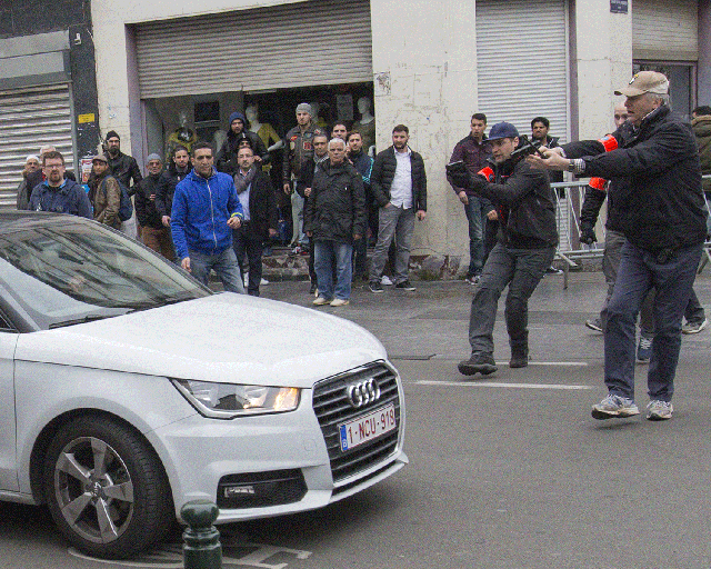 Belgian police point their guns at a car driving towards a police road block before it hit and injured a woman on the street in the Brussels district of Molenbeek, Belgium, April 2, 2016.