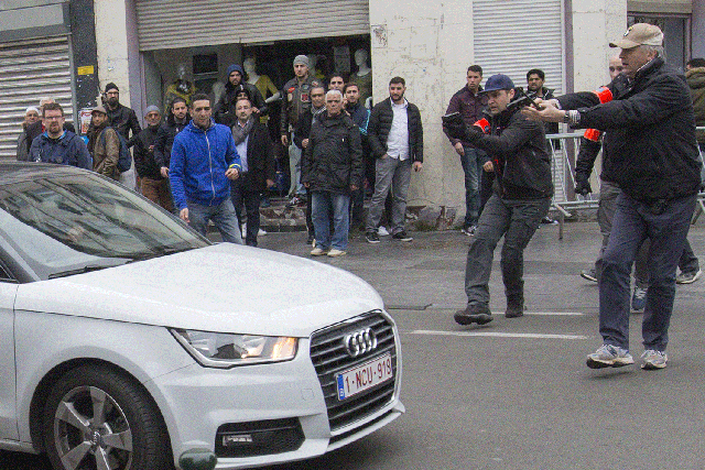 Belgian police point their guns at a car driving towards a police road block before it hit and injured a woman on the street in the Brussels district of Molenbeek, Belgium, April 2, 2016.