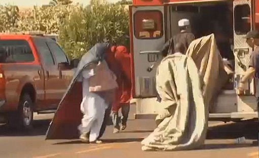 Men rushed to the ambulance with blankets covering their heads