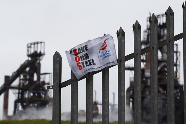 A union banner hanging from a fence in front of the Tata steelworks in the town of Port Talbot, Wales