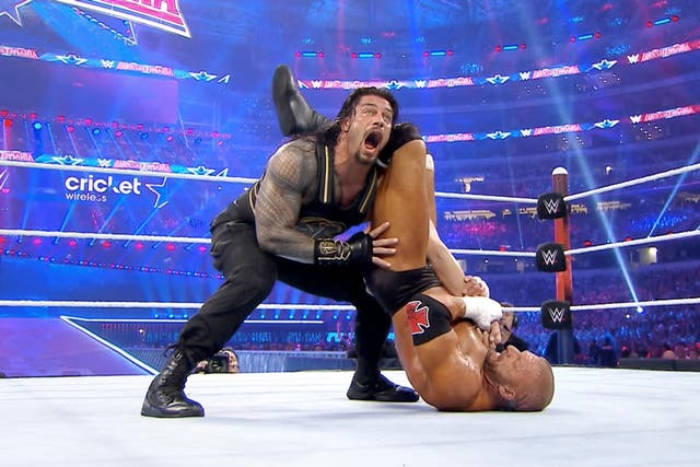 Triple H locks Roman Reigns in an arm bar during their WrestleMania match
