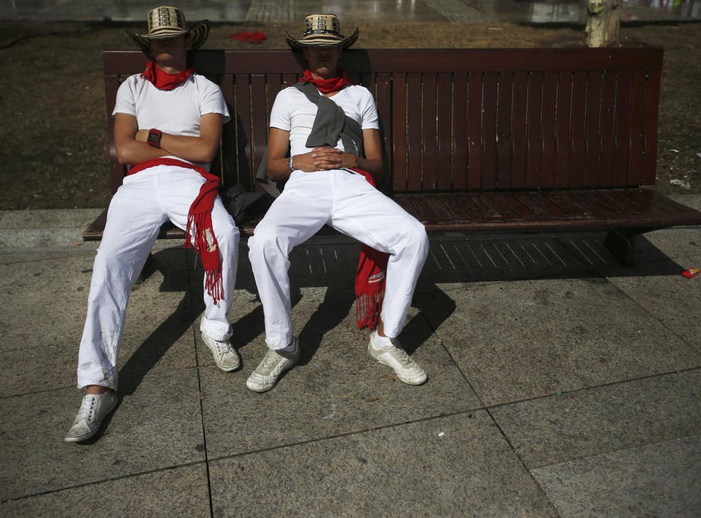 Revellers sleep on a bench after the second running of the bulls during the San Fermin festival in Pamplona