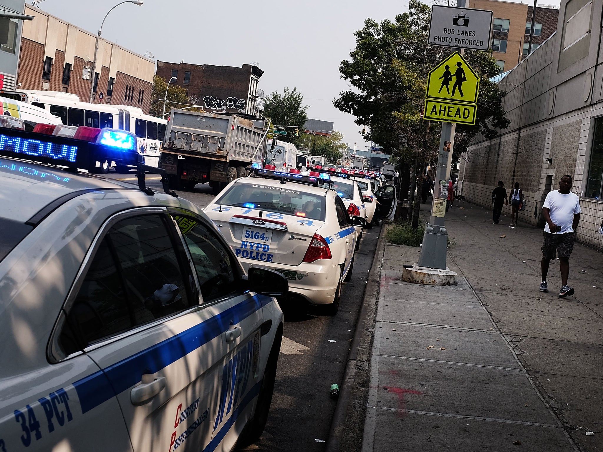 NYPD cars parked alongside sidewalk in East Harlem neighborhood Getty Images/Spencer Platt