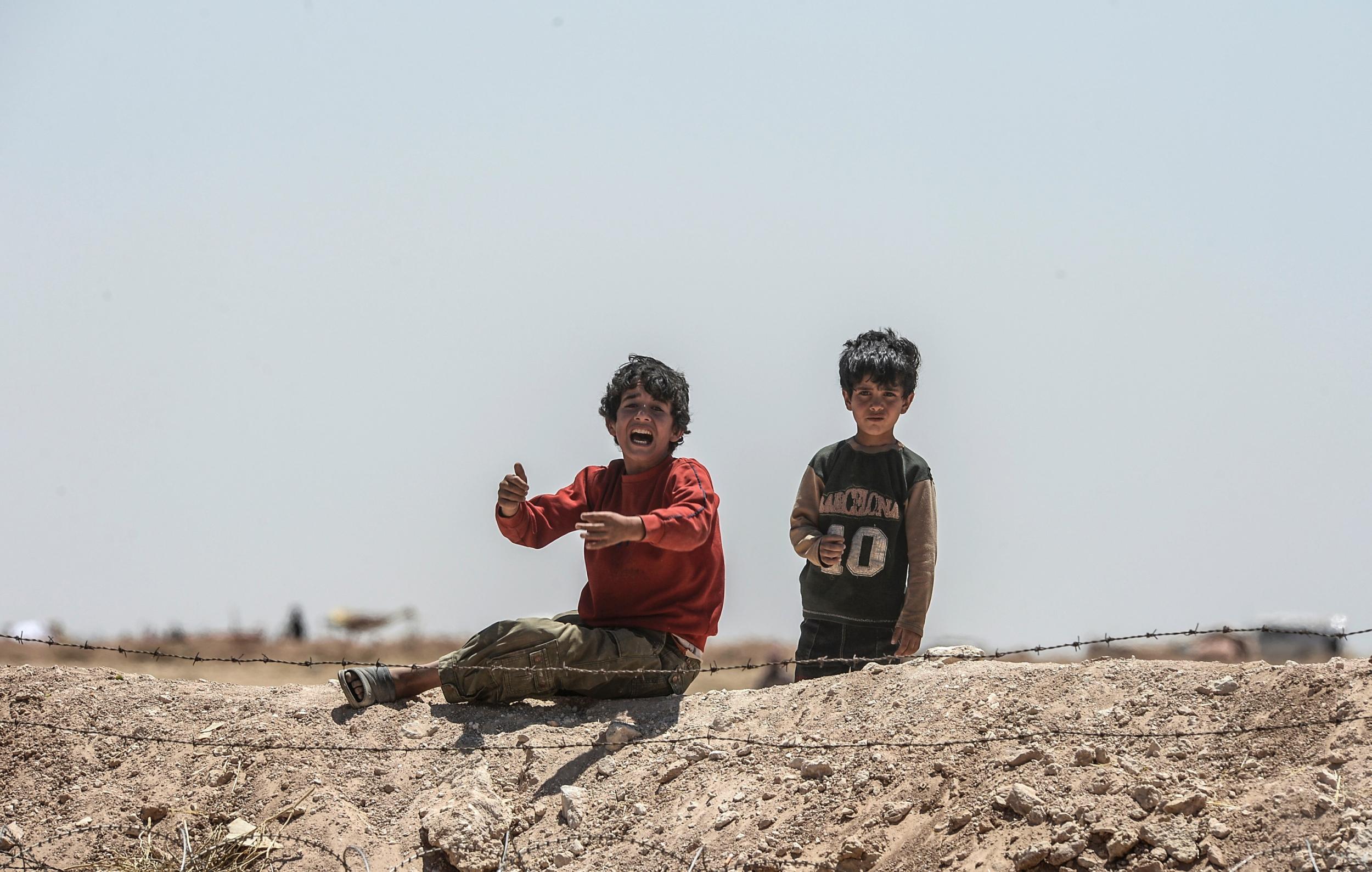 Syrian refugees ask for water in Akcakale at the Turkish border near the Syrian town of Tal Abyad