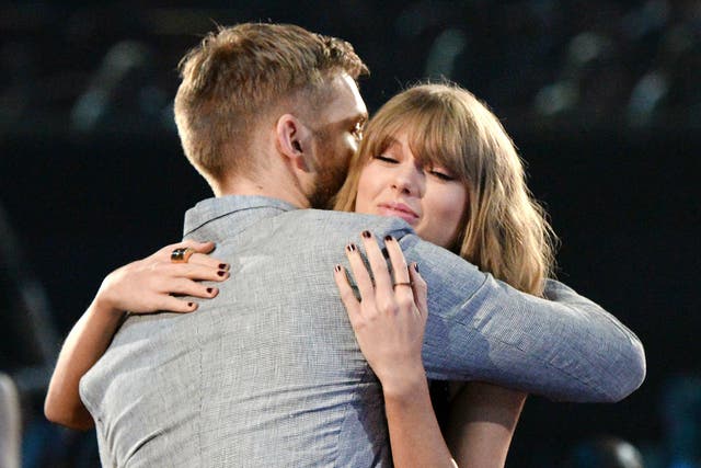 Calvin Harris and Taylor Swift hug during the iHeartRadio Music Awards