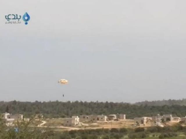 A pilot parachutes from a plane that was shot down in this still image taken from video footage