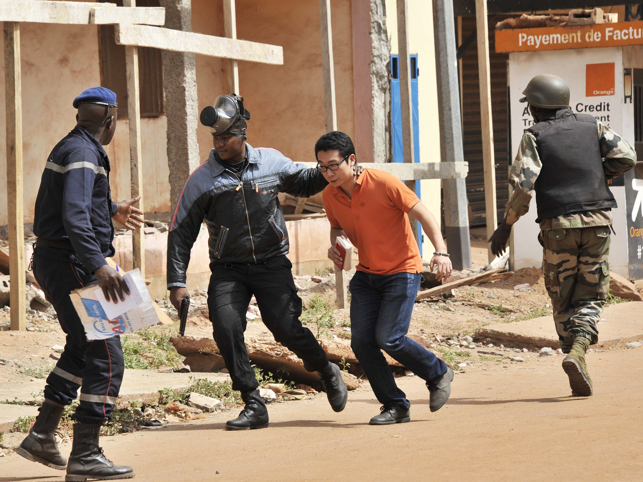 Soldiers helping a man flee the Radisson Blu hotel in Bamako, Mali, during an attack by al-Qaeda-linked jihadists in November