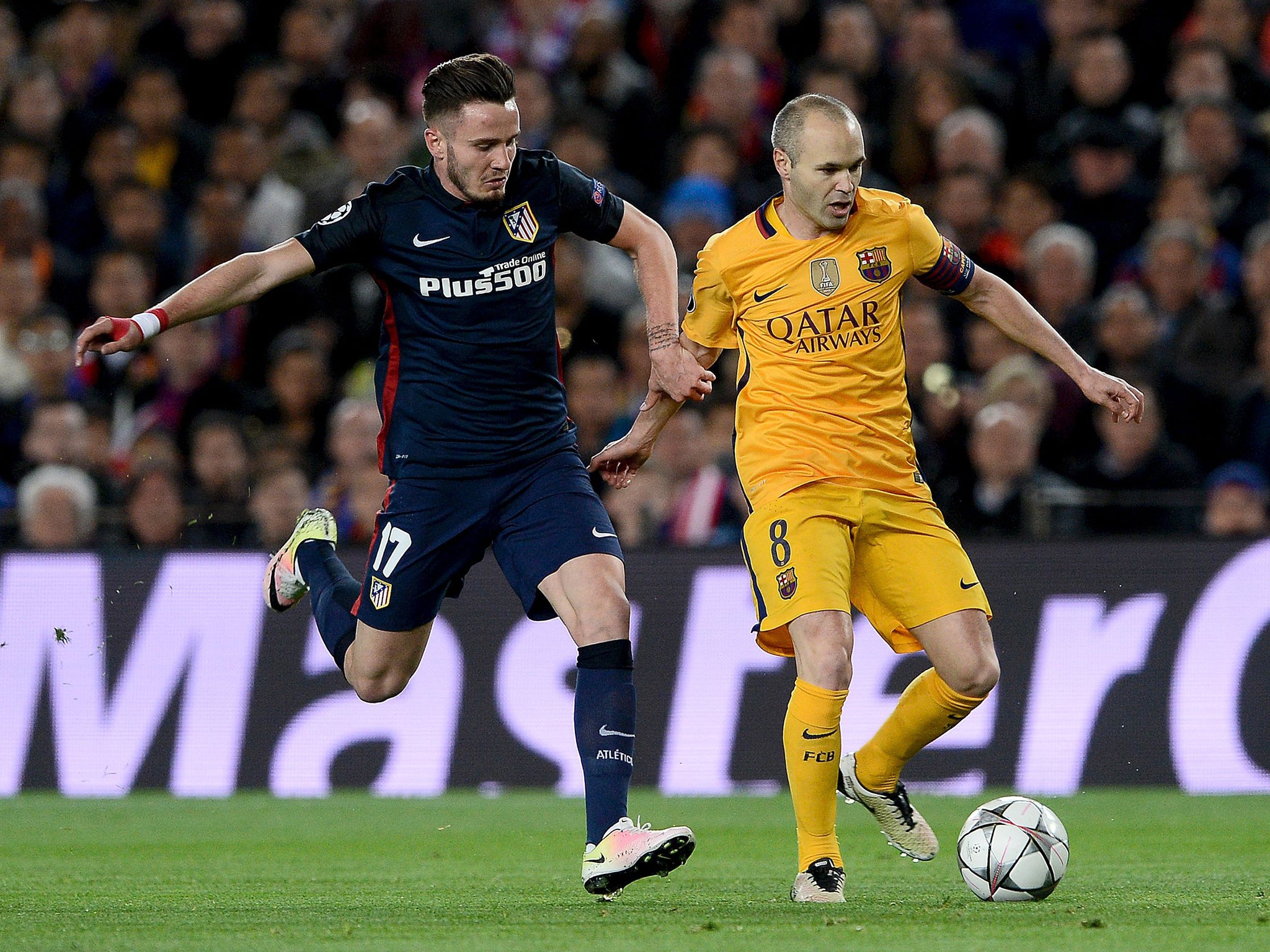 Andres Iniesta holds off Saul Niguez