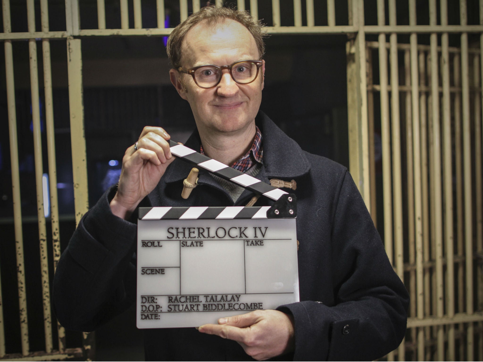 Mark Gatiss holds up a clapperboard proclaiming the start of Sherlock series four filming