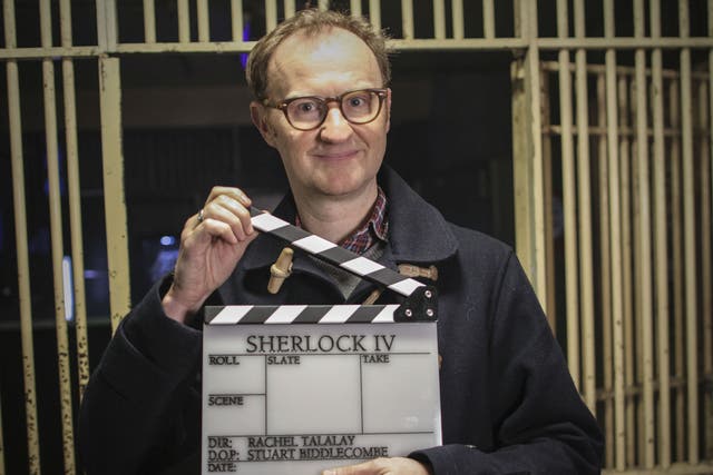 Mark Gatiss holds up a clapperboard proclaiming the start of Sherlock series four filming