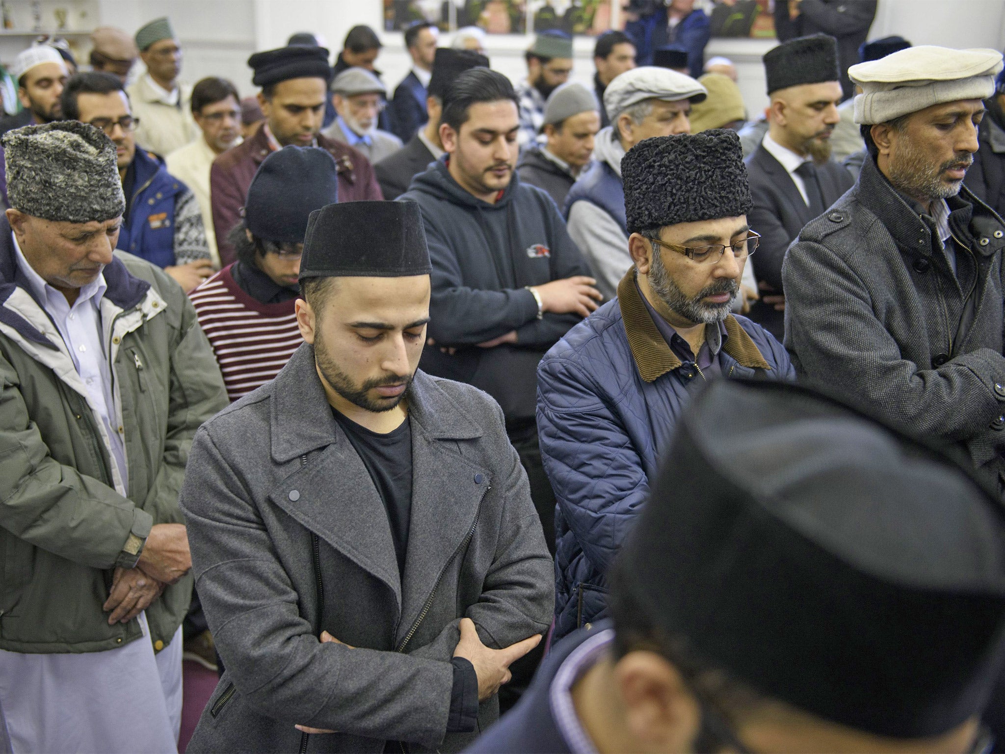 Members of Glasgow's Ahmadiyya Muslim community bow their heads at his funeral