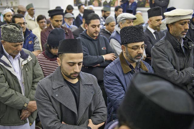 Members of Glasgow's Ahmadiyya Muslim community bow their heads at his funeral