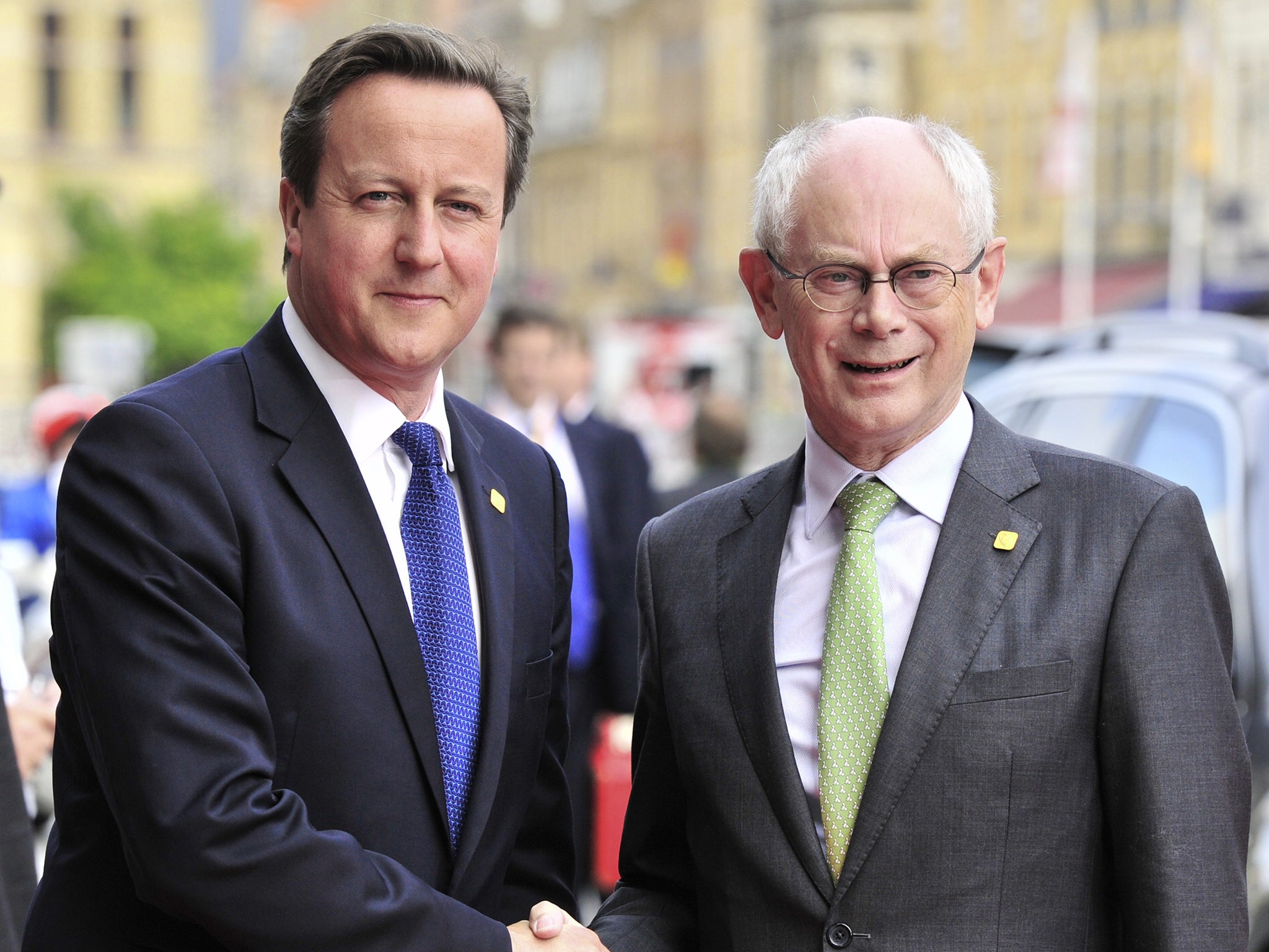 Former European Council President Herman Van Rompuy shakes hands with British Prime Minister David Cameron