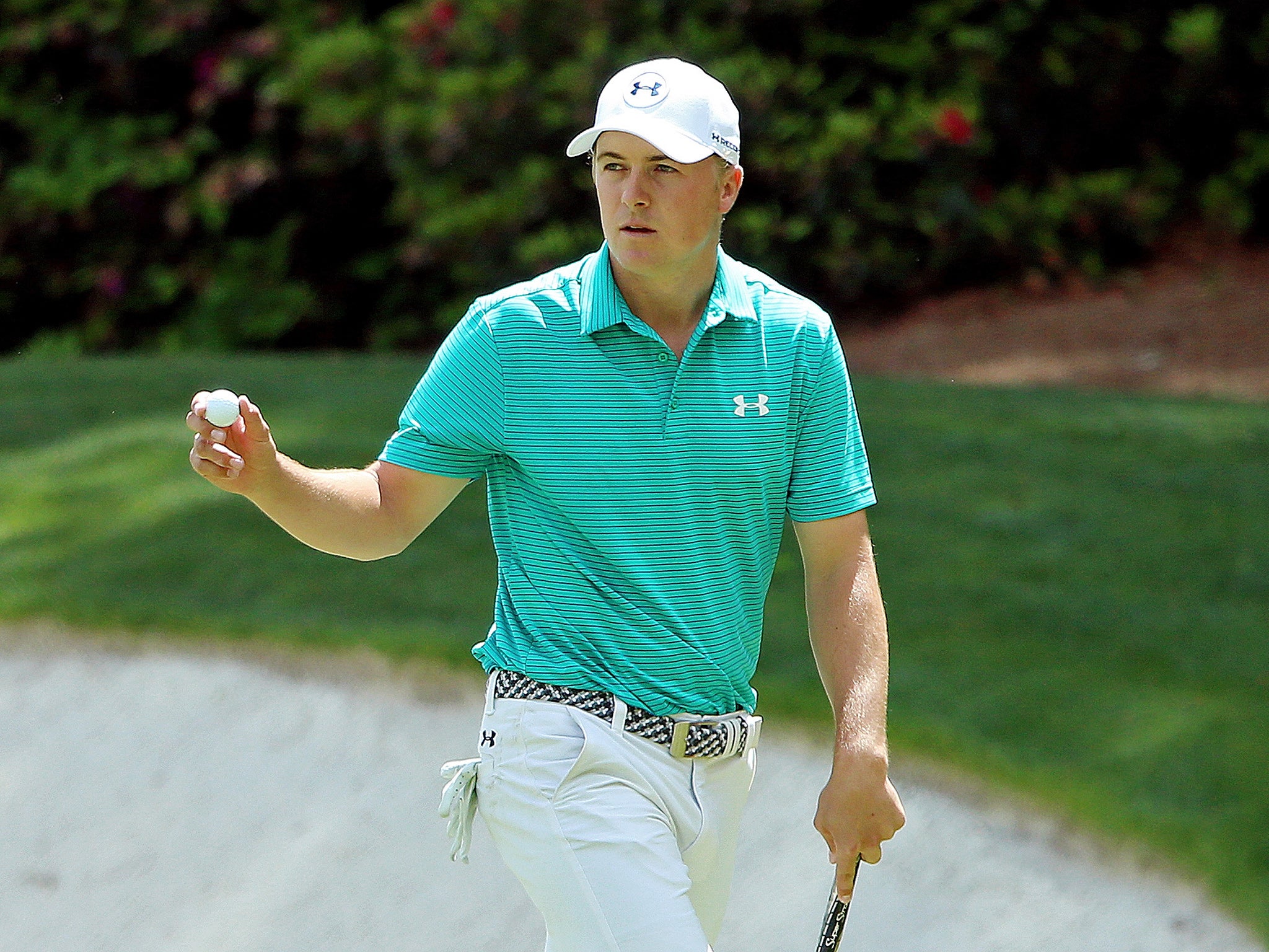 Spieth holds up his ball after putting for birdie on the 13th green