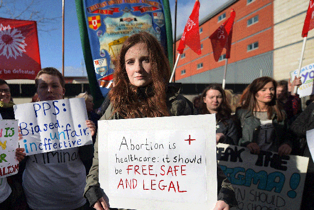 A pro-choice supporter carries a placard which reads 'Abortion is healthcare, it should be free, safe and legal'