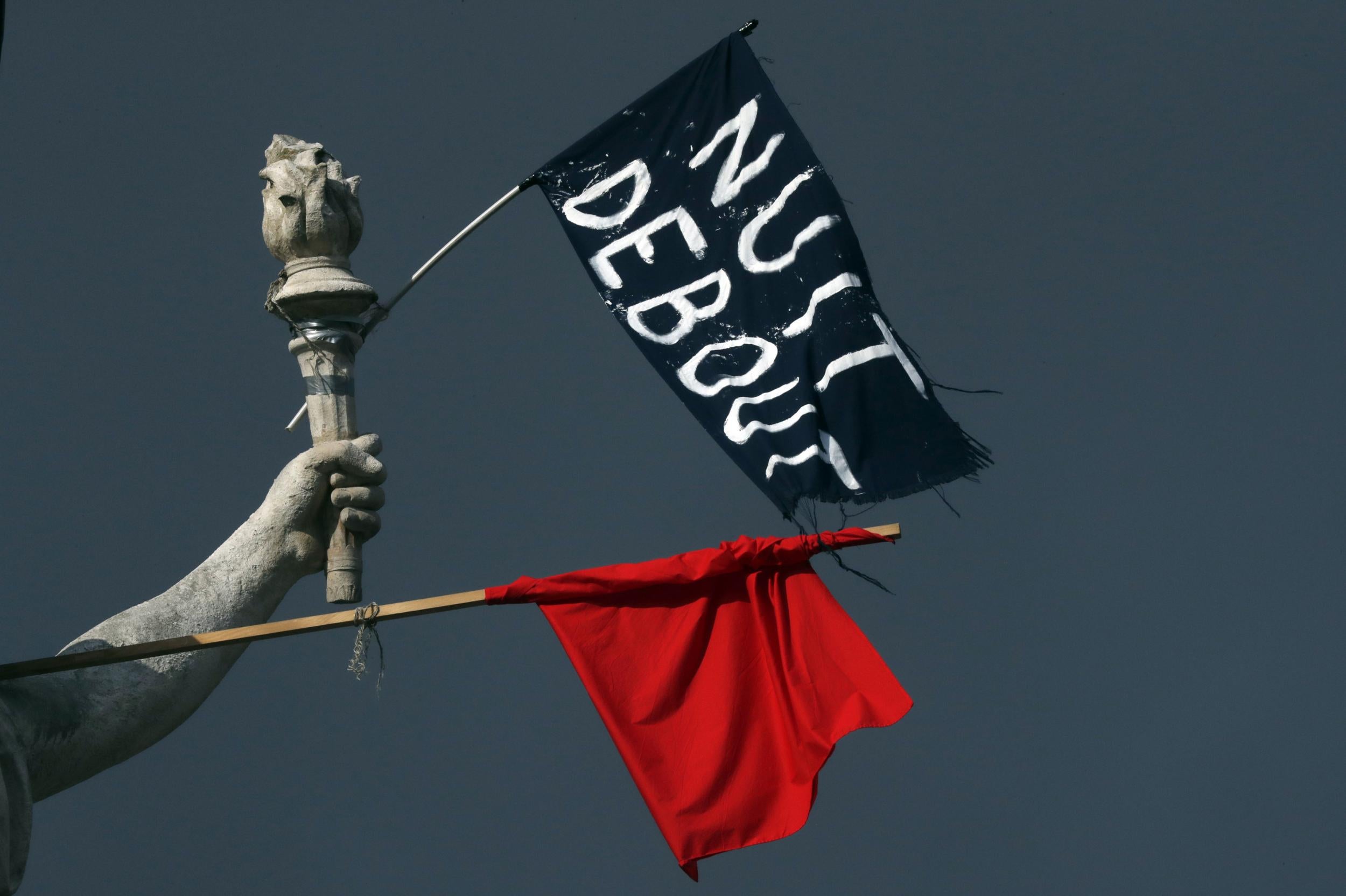 Flags of the 'Nuit Debout' movement hang off a statue in Place de la Republique in Paris