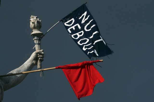 Flags of the 'Nuit Debout' movement hang off a statue in Place de la Republique in Paris