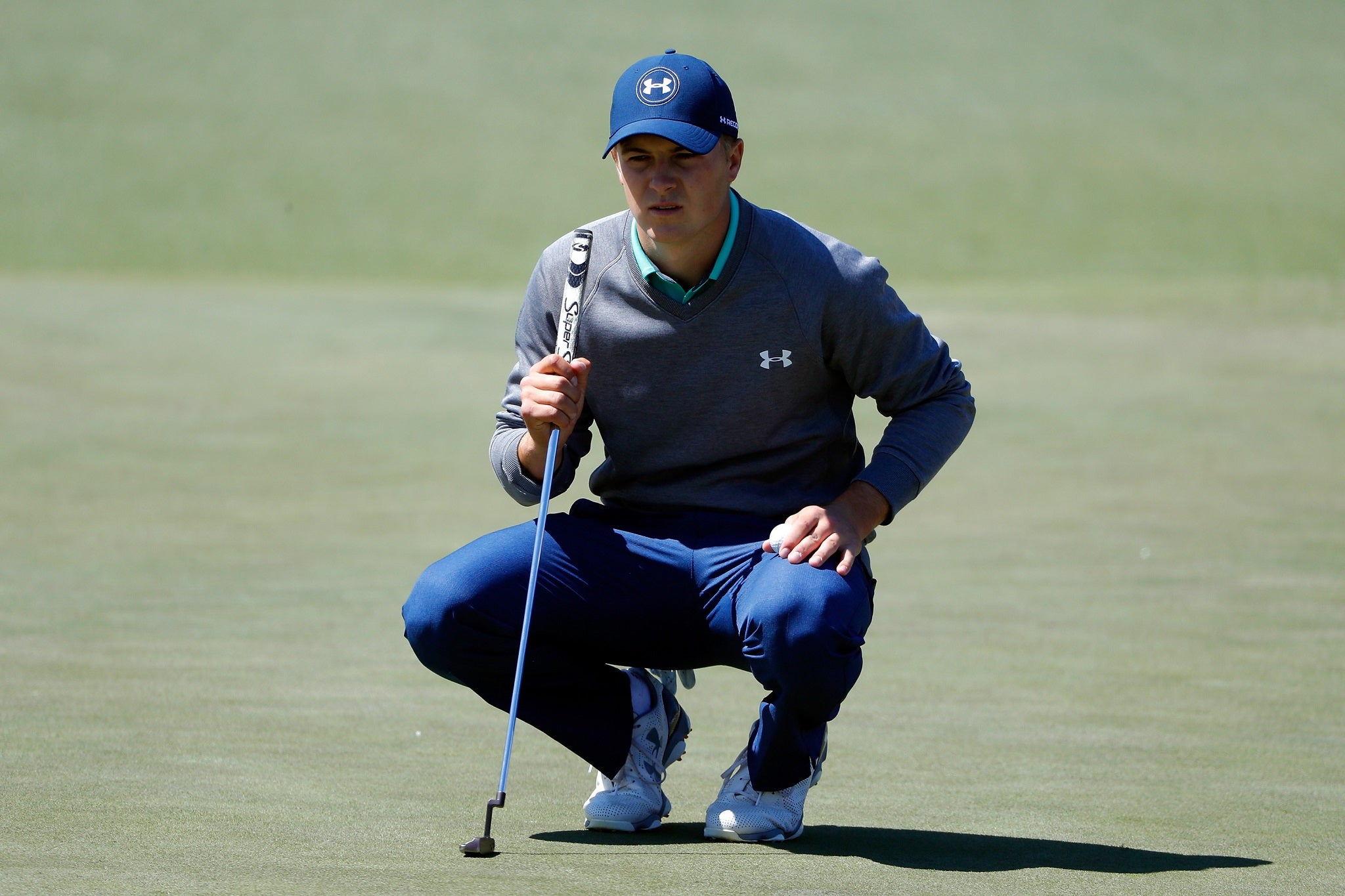 Jordan Spieth lines up a putt on the first hole