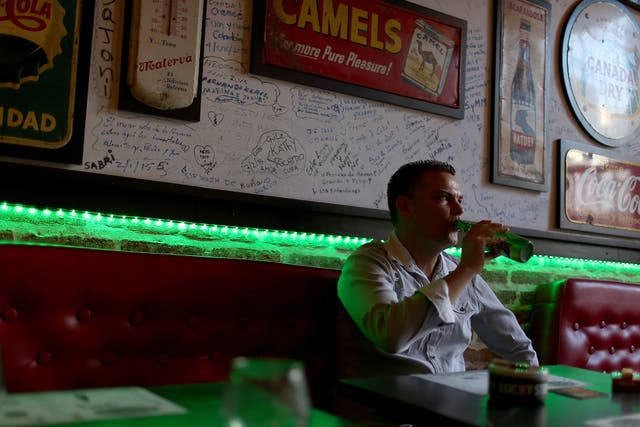 A Cuban man enjoys a beer at a new privately-owned restaurant on February 23, 2015 in Havana.
