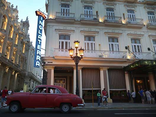 An 1950s American classic car drives past the Hotel Inglaterra in central Havana