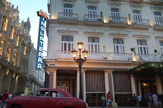 An 1950s American classic car drives past the Hotel Inglaterra in central Havana