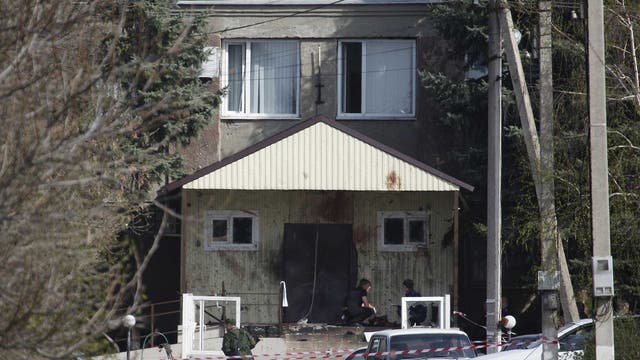 Investigators work near the entrance of a police station which was attacked in a settlement of the Novoselitsky district in Stavropol region