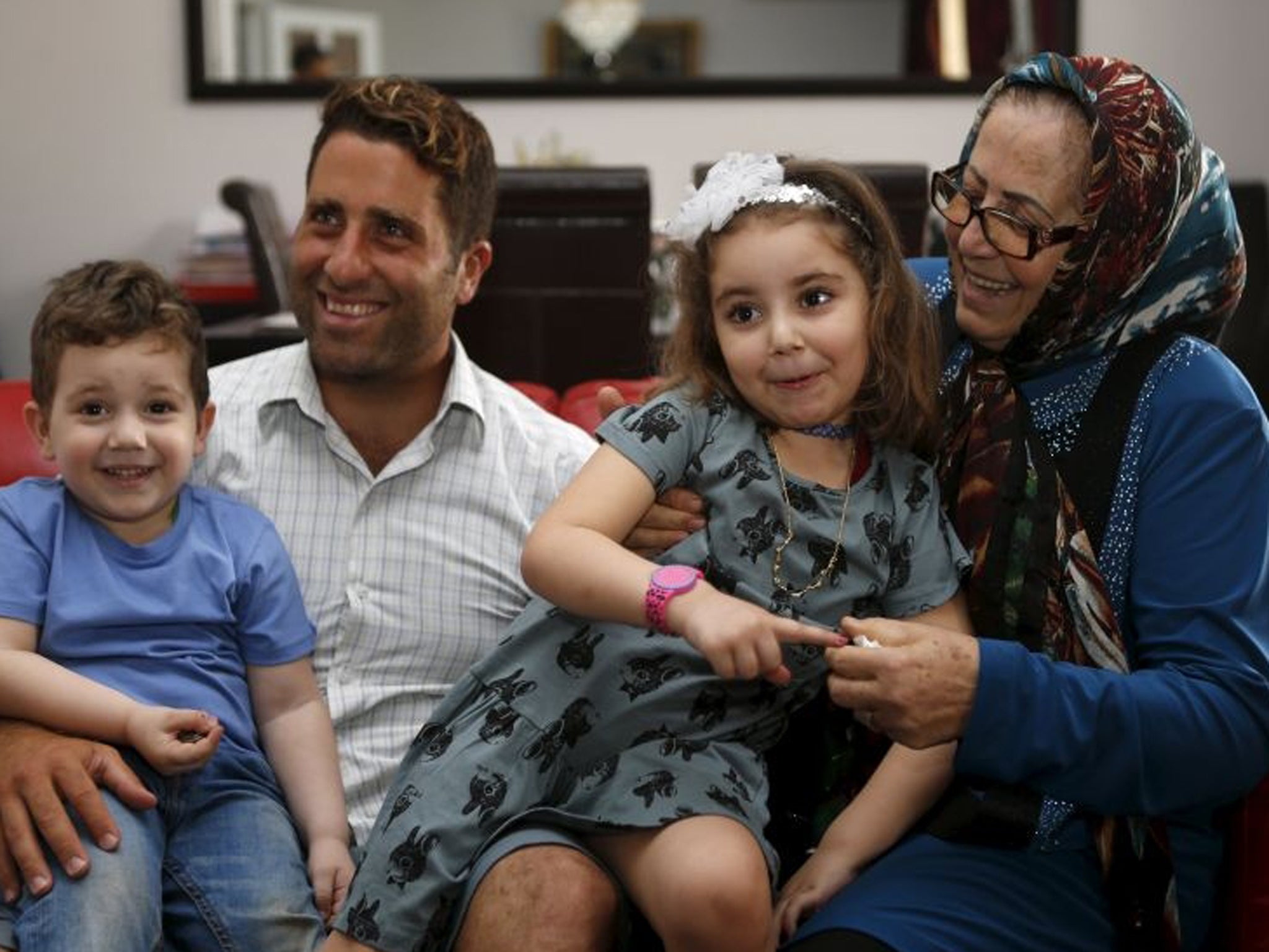 Noah and Lahela al-Amin pose for a picture with their father Ali Zeid al-Amin and grandmother in their family home in Beirut, Lebanon, 8 April, 2016
