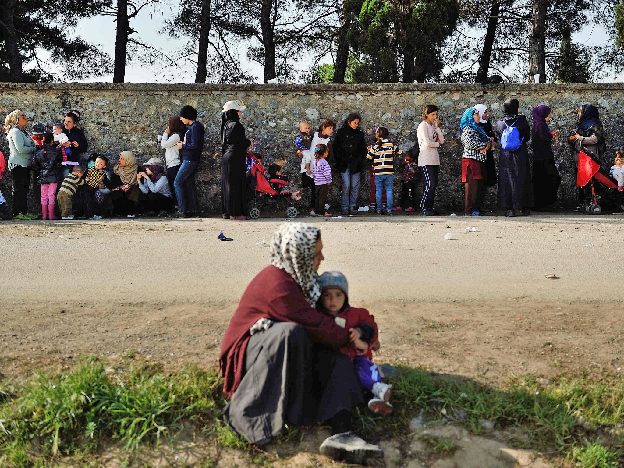Refugees wait in line for food near the Greek-Macedonian border