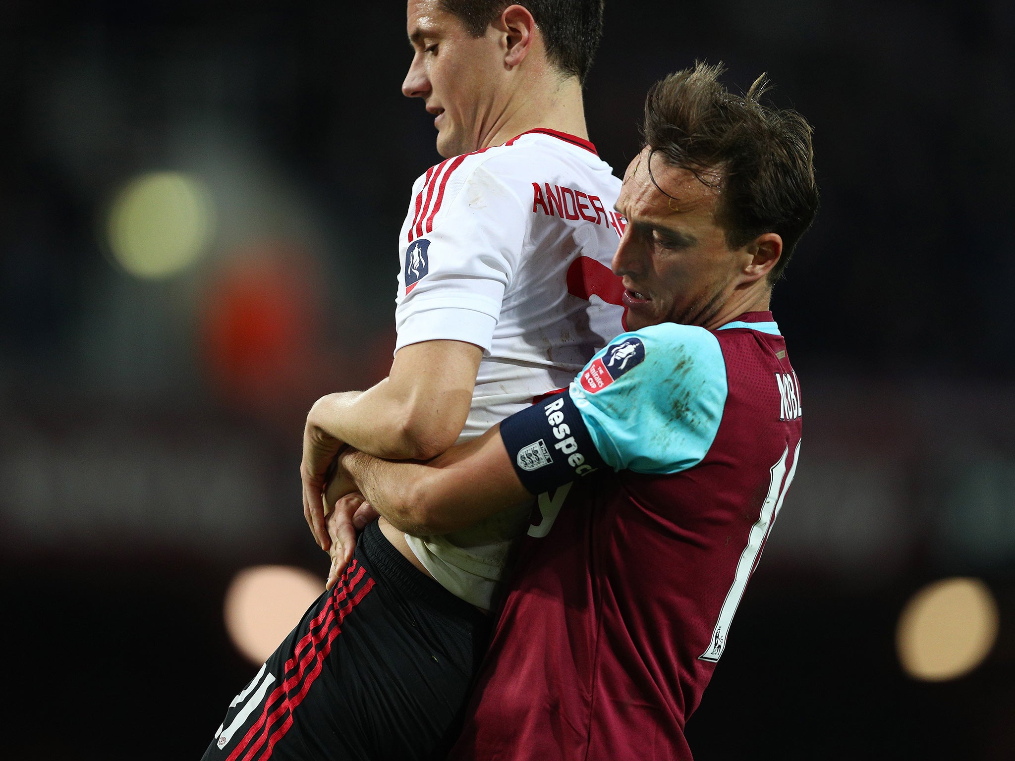 Noble carries the injured Herrera off the field