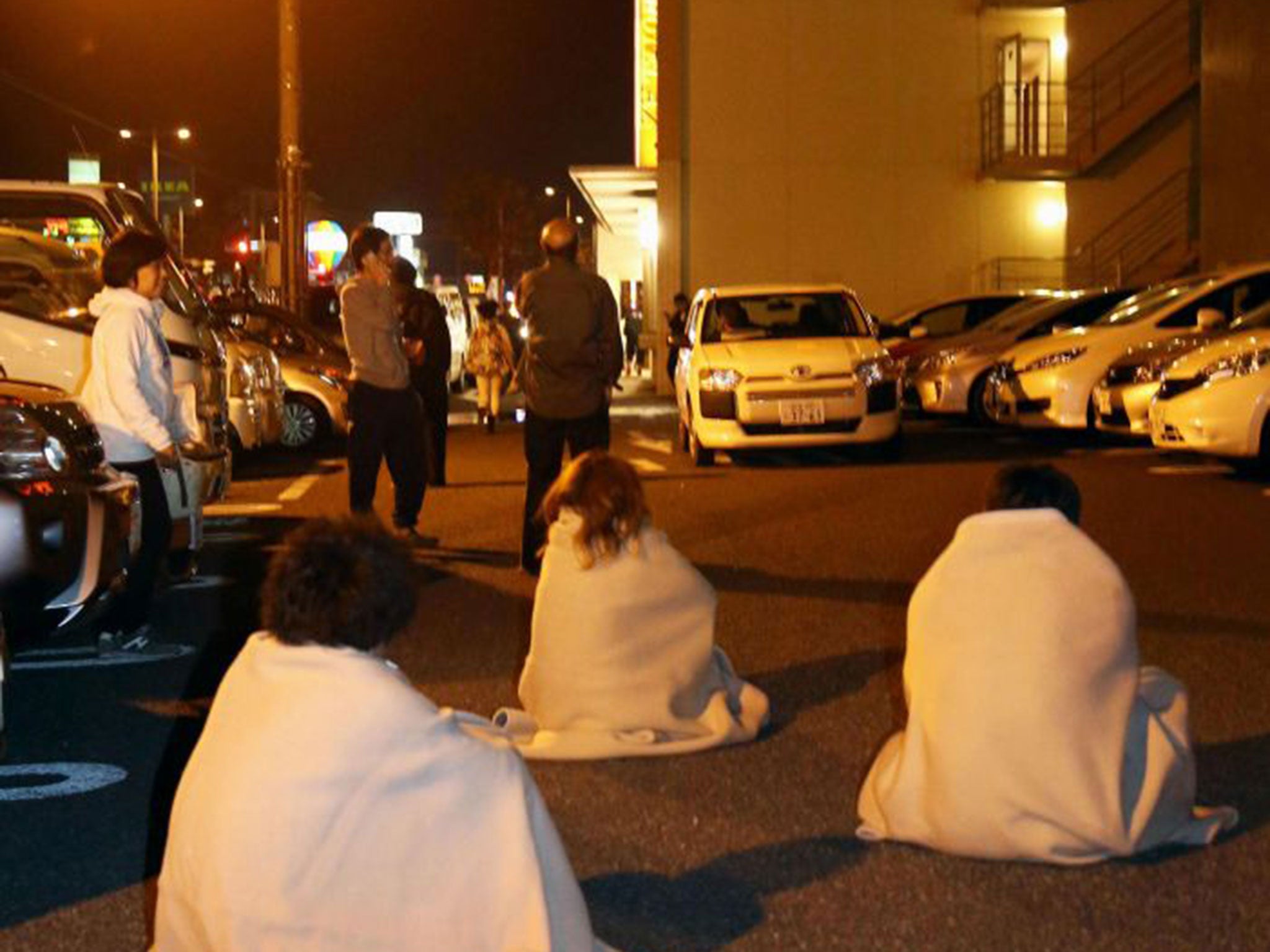 Hotel guests wait in a car park after being evacuated following the earthquake